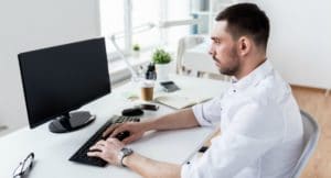 Man typing on computer in office